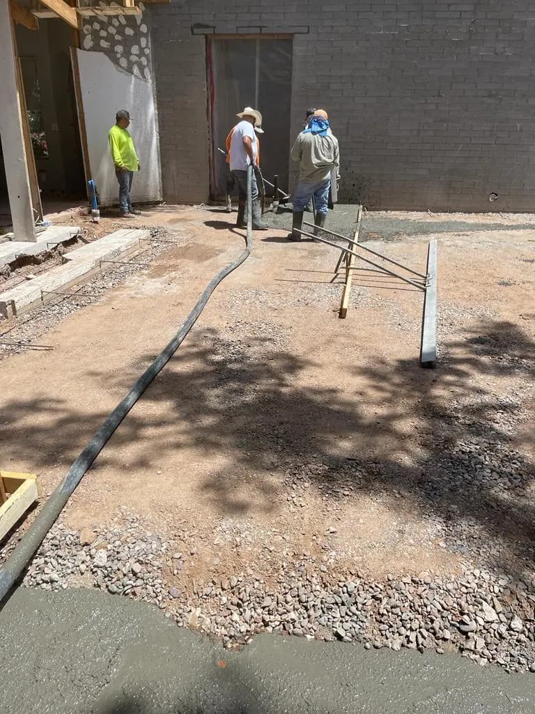 Crew placing concrete through a hose inside a structure under construction