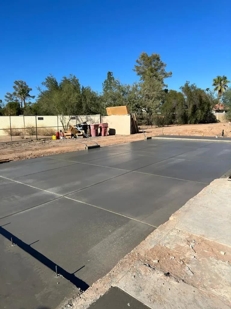 Large finished concrete slab extending an existing concrete area in a backyard