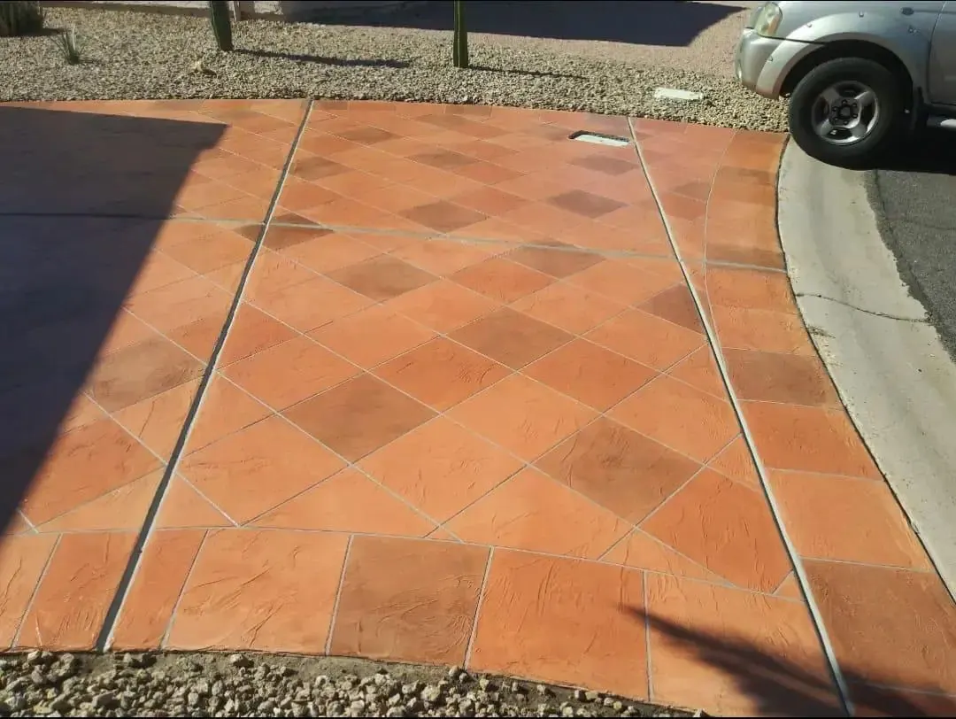 Terracotta-stained stamped concrete laid in a diamond tile pattern with a curved contrasting border band